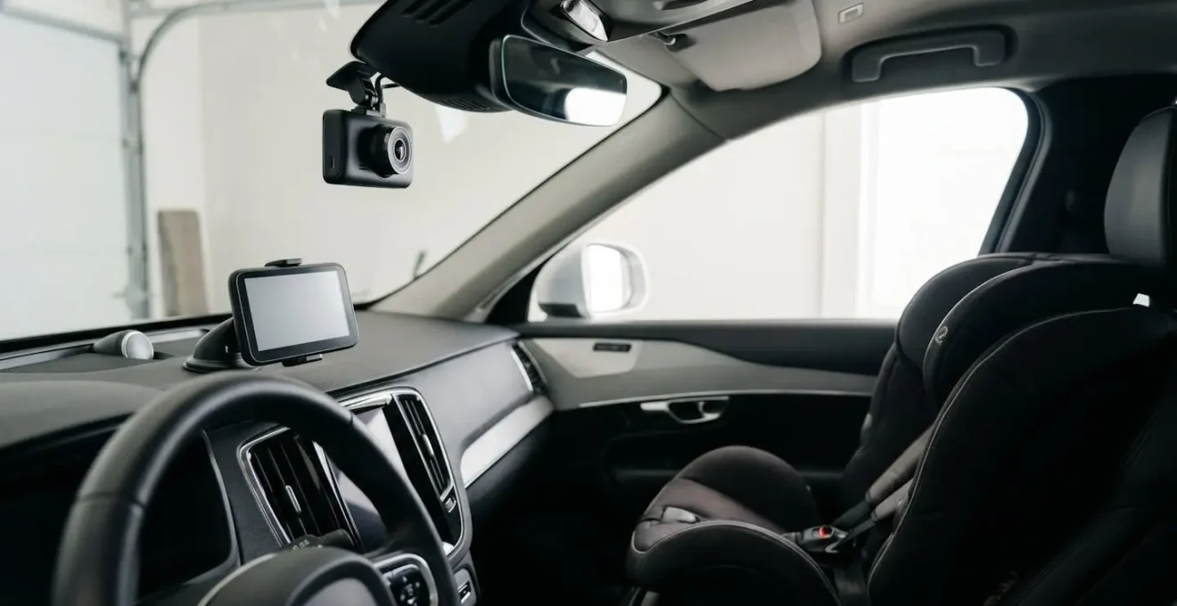 Composition d'accessoires automobiles essentiels incluant dashcam, GPS et siège bébé dans un environnement automobile naturel et réaliste