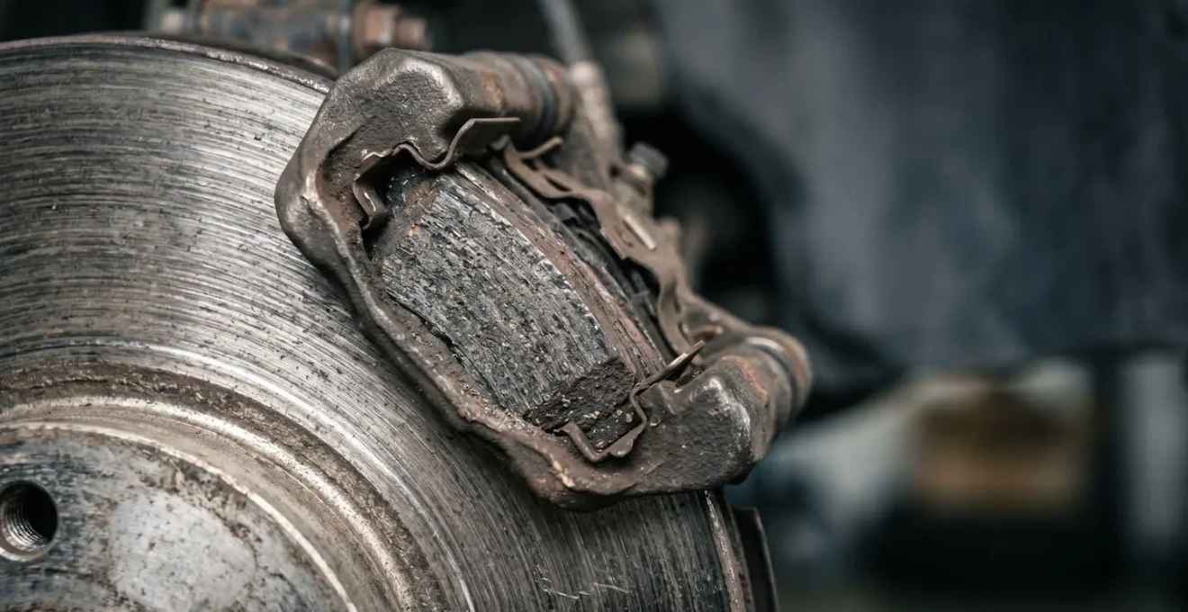 Gros plan de plaquettes et disque de frein automobile montrant l'usure naturelle