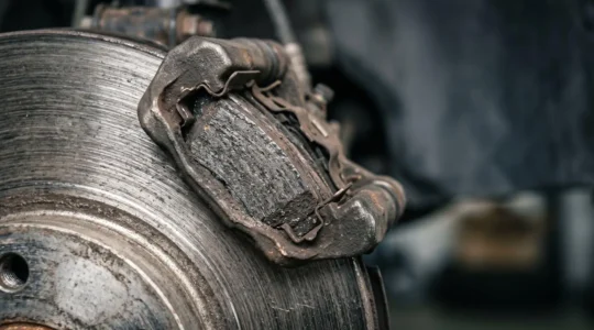 Gros plan de plaquettes et disque de frein automobile montrant l'usure naturelle